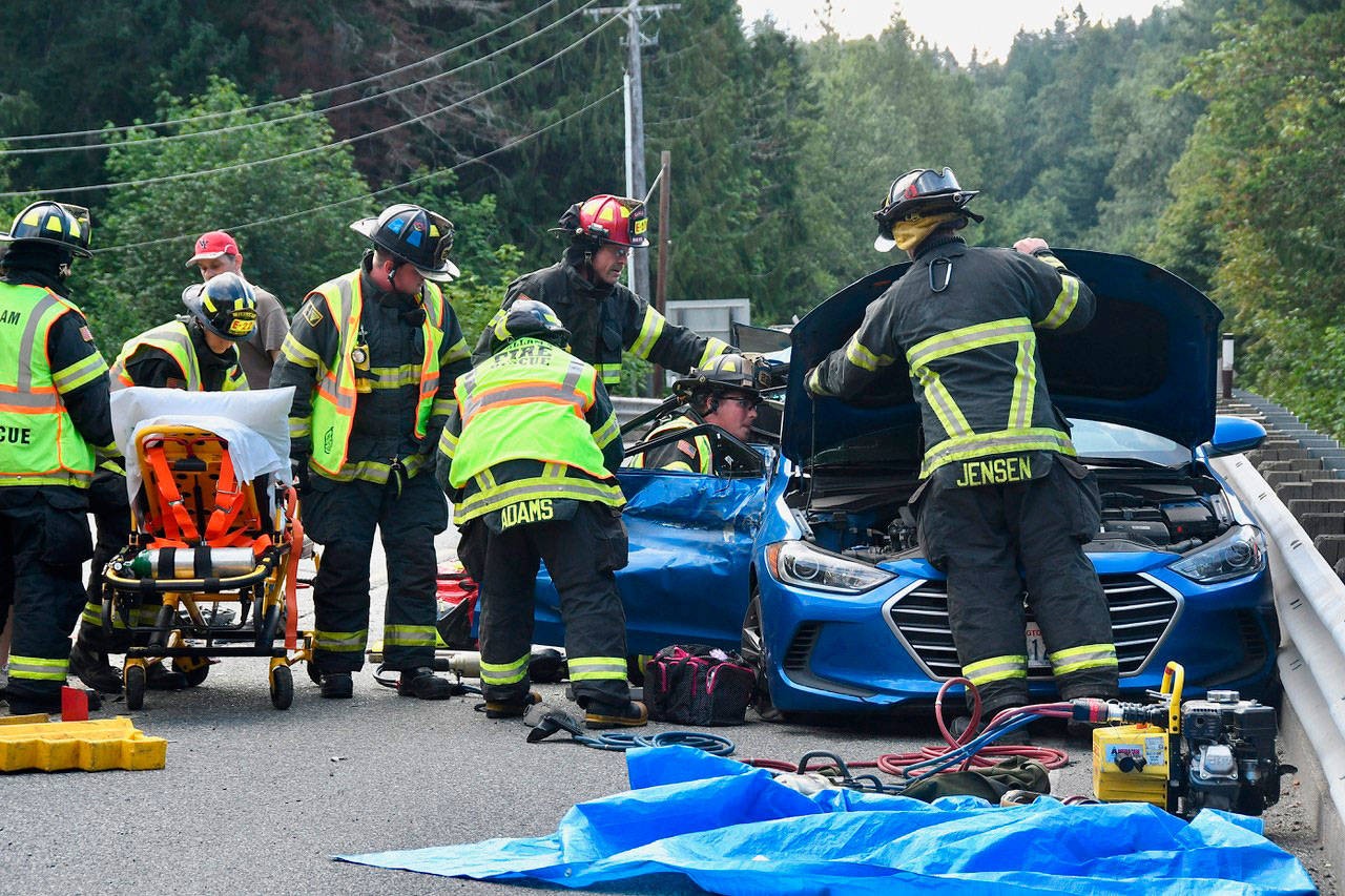 Firefighter/EMT personnel work to extricate two trapped occupants of a vehicle involved in a six-vehicle crash on the Elwha River Bridge on July 24. Photo courtesy of Clallam County Fire District No. 2