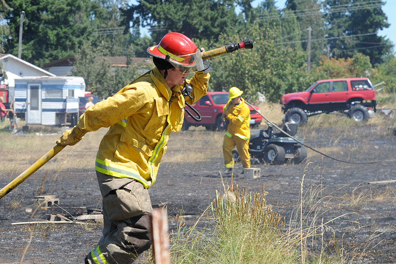Fire District 3 personnel put out “hot spots” at a brush fire in Carlsborg on July 26. Sequim Gazette photo by Michael Dashiell