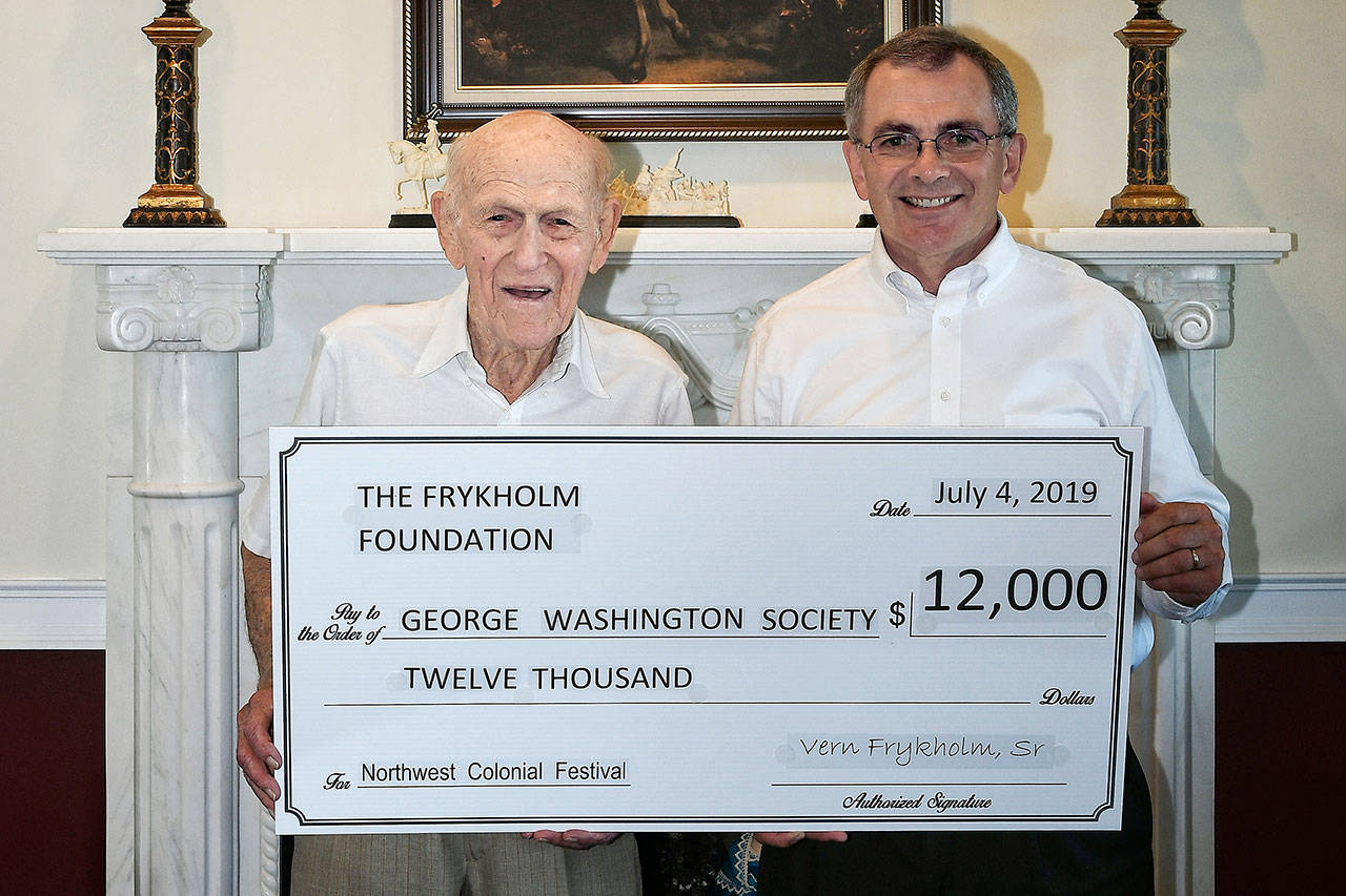 Vern Frykholm Sr. offers a donation to Dan Abbott, President of the George Washington Society, to support the 2019 Northwest Colonial Festival, set for Aug. 8-11, 2019. Submitted photo