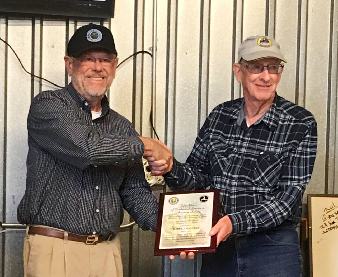 Barry J. Halsted, right, receives the Wright Brothers Master Pilot Award from Ray Ballantyne, representing the FAA Northwest Mountain Flight Standards Division, at the Sequim Valley EAA Chapter 430 monthly gathering on July 27. Submitted photo