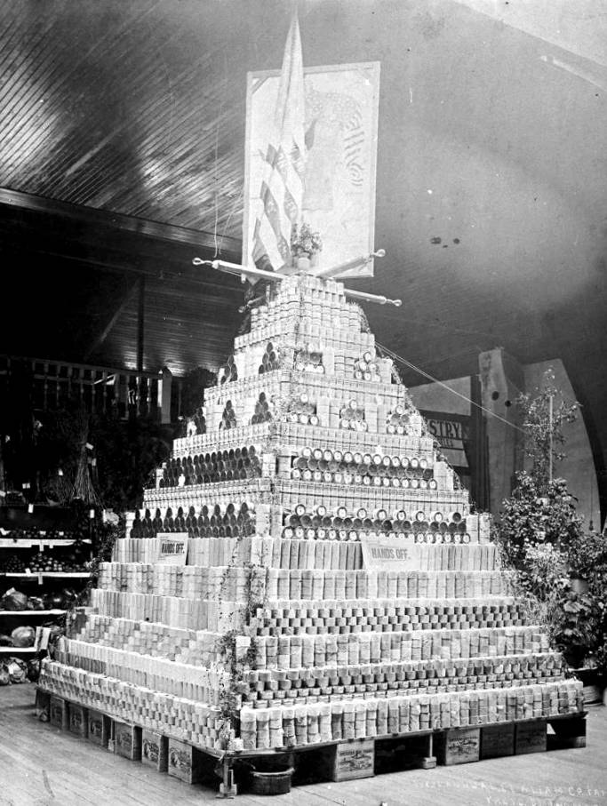 A display of canned salmon looms large at the first Clallam County Fair, October 1895. Arranged by the National Packing Company, the pyramid of cans were arranged on top of boxes with labels reading “American Flag Brand Salmon.” Photo courtesy of Washington State Library