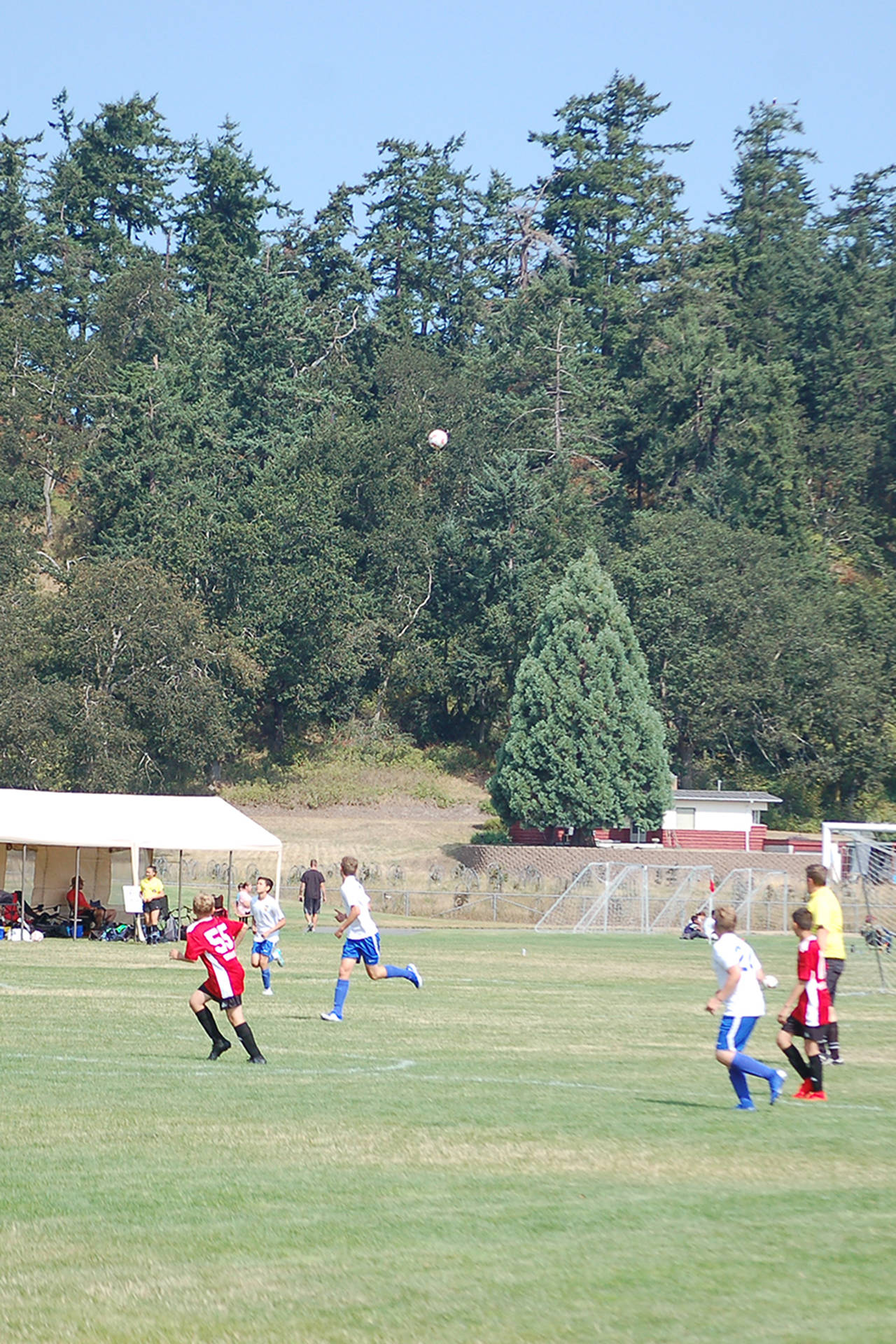 Members of the North Kitsap Force (white shirts) and Franklin Pierce Raptors (red shirts) boys U15 teams track a high ball during their match on Aug. 3 in the Dungeness Cup. North Kitsap eventually won the match 5-0 and finished fourth in their group. Sequim Gazette photo by Conor Dowley.