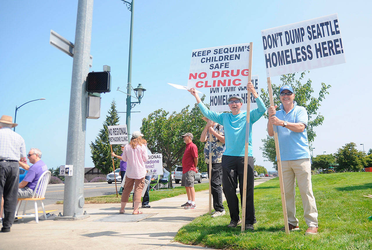 Chuck Nation, far right, and Fred Swenson, second from right, join more than two dozen people with signs at the intersection of Priest Road and West Washington Street Saturday, opposing a proposed Medication Assisted Facility on Aug. 3. Save Our Sequim chair Jodi Wilke,said a goal of the turnout is to help educate residents about the topic. “We haven’t gotten a whole lot of negative (responses),” Wilke said. Sequim Gazette photo by Michael Dashiell