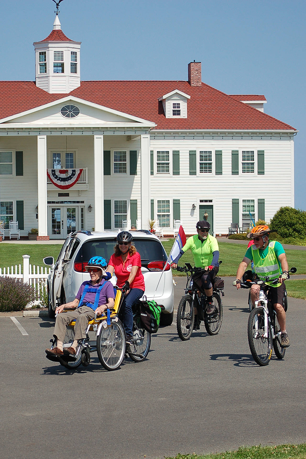 As part of a special Sequim Wheelers ride event at the Tour de Lavender, Vern Frykholm, left, is piloted by Lanie Cates as they ride away from the George Washington Inn. The Sequim Wheelers are an organization that provides bicycle rides to the elderly and disabled who otherwise couldn’t ride. Sequim Gazette photo by Conor Dowley.