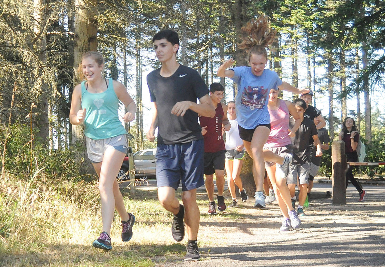 Sequim cross country runners (from left) Emily Silva, Darren Salazar and Riley Pyeatt and teammates get some preseason work in at Robin Hill County Park last week. Sequim Gazette photo by Michael Dashiell
