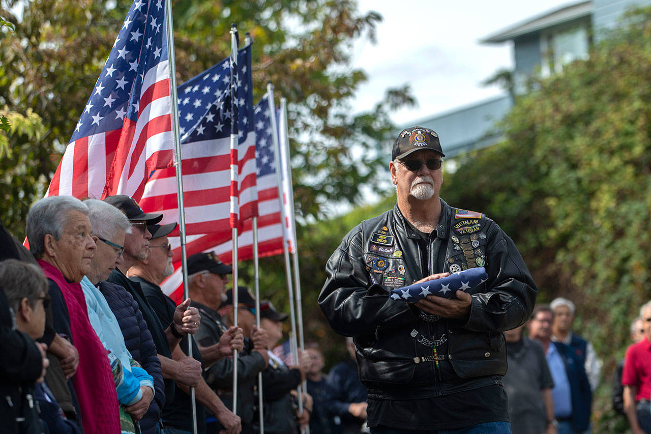 American Legion Rider Ralph Ellsworth presents the American flag during a ceremony in Port Angeles honoring public safety officials on the 18th anniversary of the 9/11 terrorist attacks Wednesday. (Jesse Major/Peninsula Daily News)