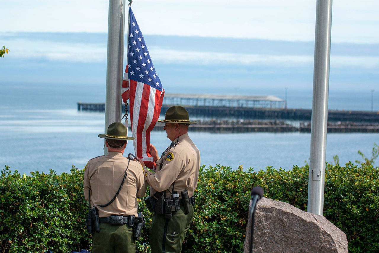 Sheriff’s deputies raise the American flag during a ceremony in Port Angeles honoring public safety officials on the 18th anniversary of the 9/11 terrorist attacks Wednesday. (Jesse Major/Peninsula Daily News)