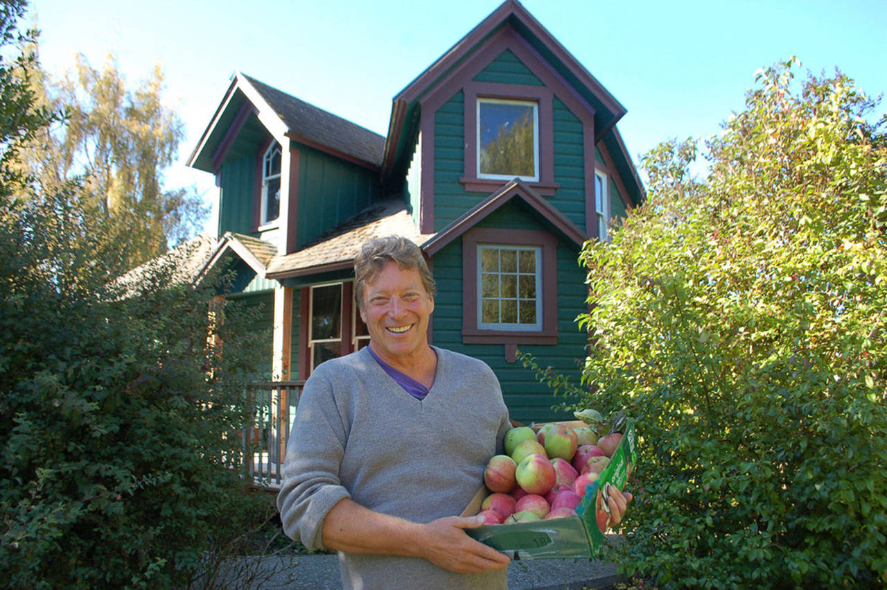 Mark Schwartz, host of Williams Manor and organizer of Applestock, poses in front of the manor with some of the apples from the orchard on the property in 2018. Sequim Gazette file photo