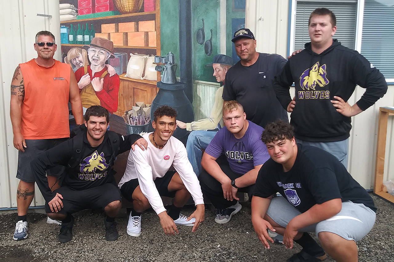 Pictured are (standing, from left) KC Eaton, coach Bob Reandeau, and Brandon Barnett, with (kneeling) Beau Halverson, Hayden Eaton, Seth Wilson and Caleb Pozernick after helping move two of the murals to the Sequim Museum & Arts center. Submitted photo