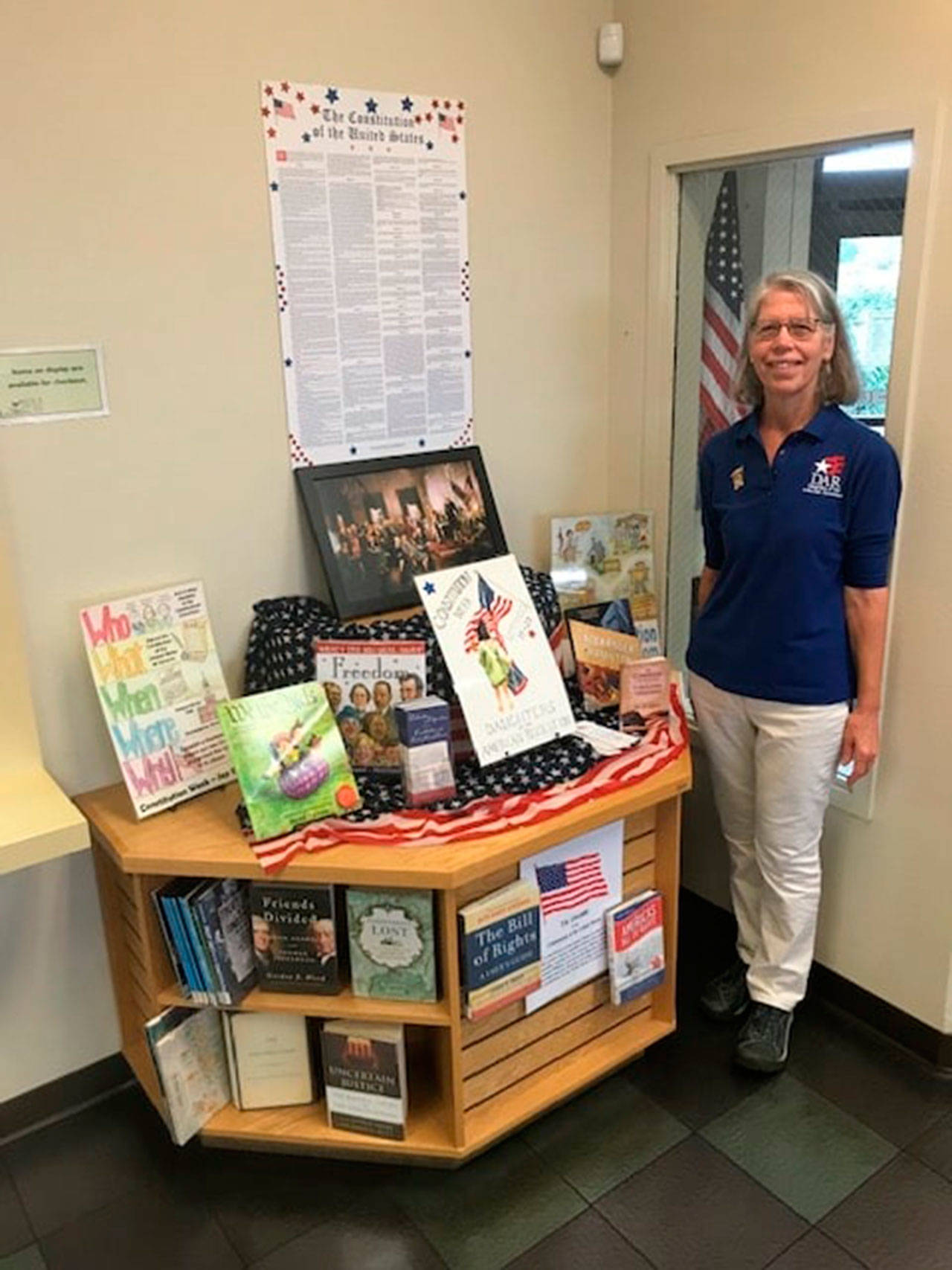 Ginny Wagner of Sequim, registrar for the Michael Trebert Chapter of the Daughters of the American Revolution, stands by a display for Constitution Week at the Sequim Library. Similar displays appeared in the Forks and Port Angeles libraries. Submitted photo