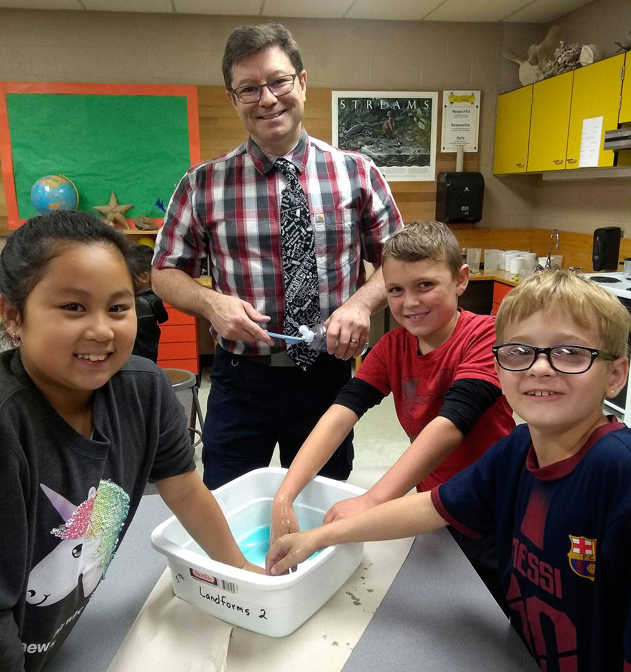 Helen Haller fourth- and fifth-grade students in K-5 STEM specialist Kieth Lee’s class make slime to conduct an investigation to determine whether the mixing of two or more substances can result in a new substance. Pictured with Lee are, from left, Taylor Thai, Fredrick Wilhelm and Gabriel Francis from Eric Danielson’s class. Submitted photo