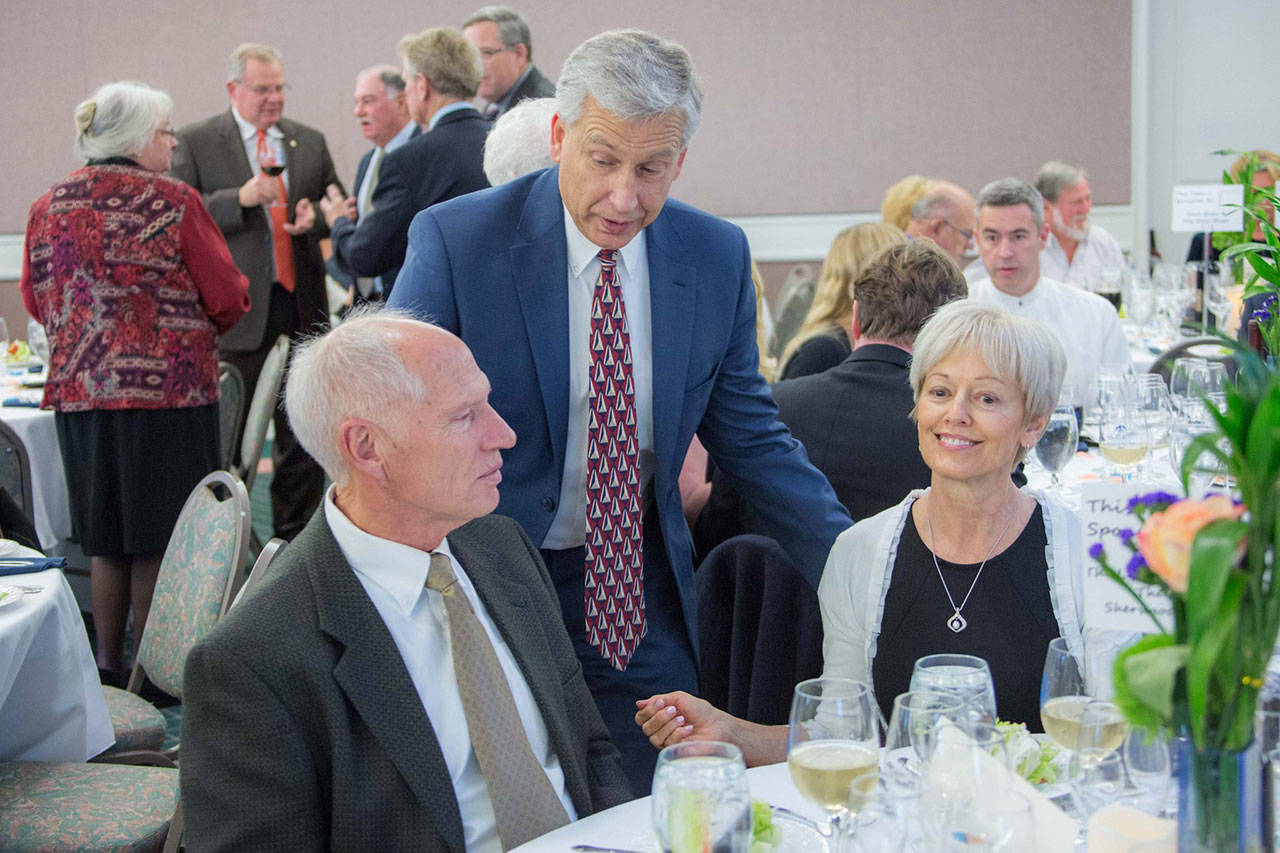 Olympic Medical Center CEO Eric Lewis, back, speaks with Bill and Esther Littlejohn of Sequim at a previous Harvest of Hope event. The Littlejohns will be presented with the Rick Kaps Award, an honor that recognizes organizations and individuals who have supported the Olympic Medical Cancer Center. Photo courtesy of Olympic Medical Center Foundation