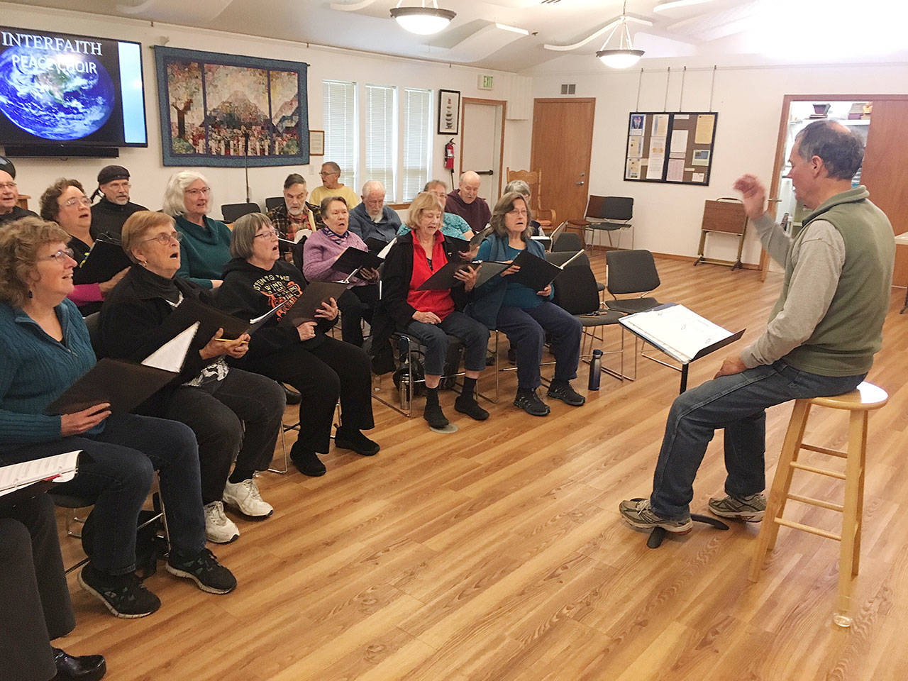 Joel Yelland directs the Interfaith Clallam County Peace Choir in a recent rehearsal. Submitted photo