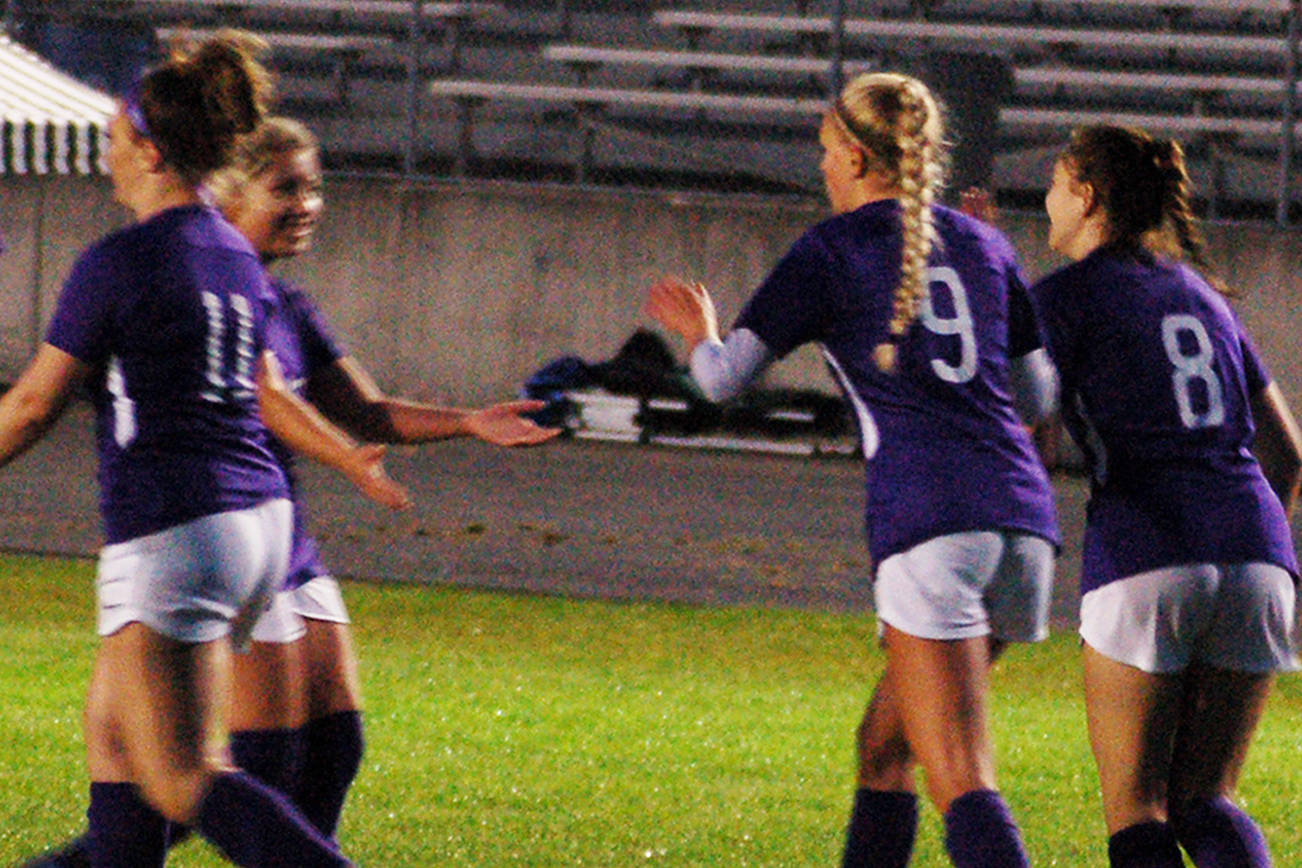 Senior forward Eden Johnson (second from right, no. 9) celebrates with her teammates after scoring Sequim’s second goal of a 5-0 win over Kingston on Oct. 3. Hanna Wagner (left, no. 14) also scored a goal on the night, and nearly scored three more on an impressive night for the sophomore forward. Sequim Gazette photo by Conor Dowley