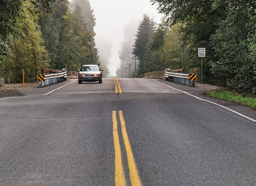 A driver crosses the Ward Bridge along Woodcock Road and over the Dungeness River this past weekend. Clallam County officials closed the bridge in late June and a section of Woodcock from milepost 2.27 to milepost 2.39 to repair the bridge’s piers and resurface its roadway. Photo by Bob Lampert