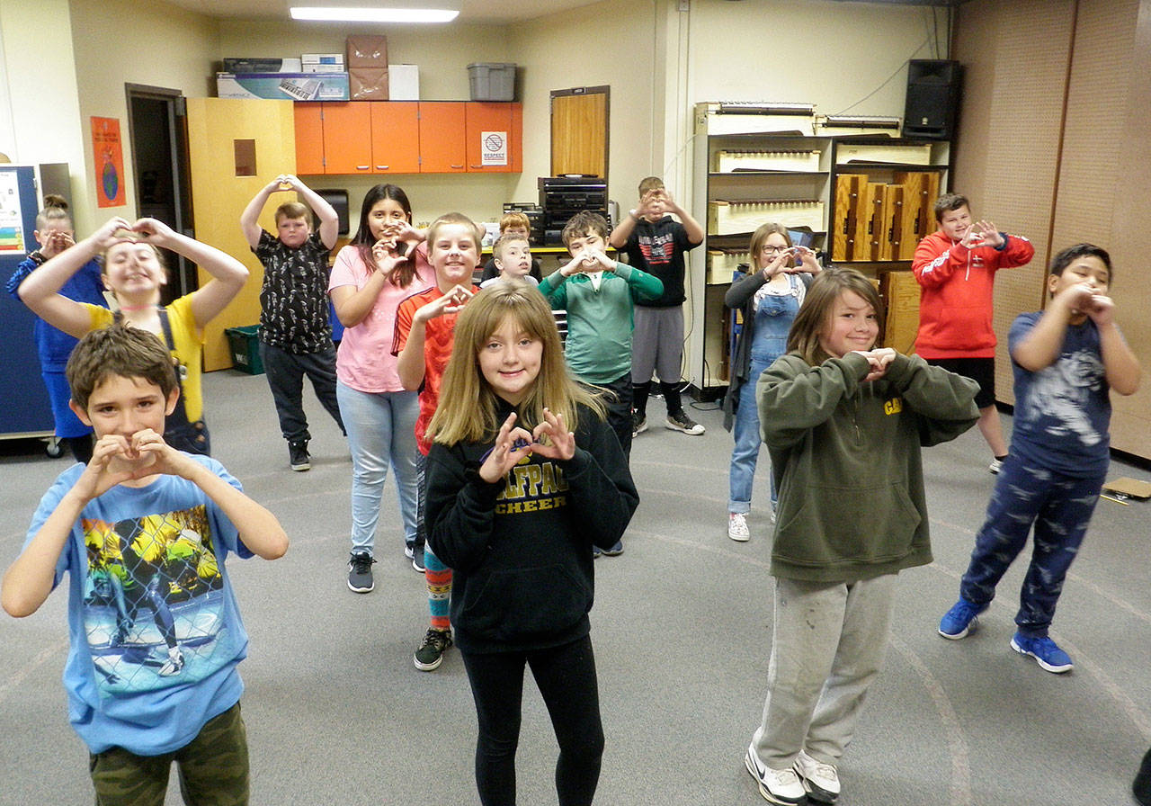 Fifth-graders from Brittney Rothwell’s class practice in music class for an upcoming choir concert in November. Music teacher Laura Lorentzen has them run through a choreographed warm-up song at the beginning of class that includes the Haller Heart hand gesture. Photo by Patsene Dashiell