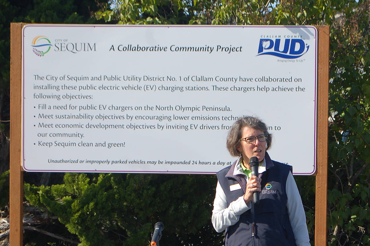 Sequim public works department resource manager Ann Soule addresses the gathered crowd of city officials, Clallam PUD officials and interested citizens at the opening of the city’s new electric vehicle charging station at the old PUD substation at 410 E. Washington St. on Oct. 11.
