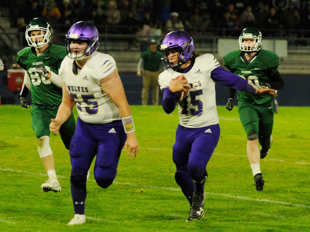 With Brandon Barnett (55) leading the way, Sequim quarterback Taig Wiker picks up a big gain in the first quarter of the Wolves’ league match-up at Port Angeles on Oct. 18. Sequim Gazette photo by Michael Dashiell