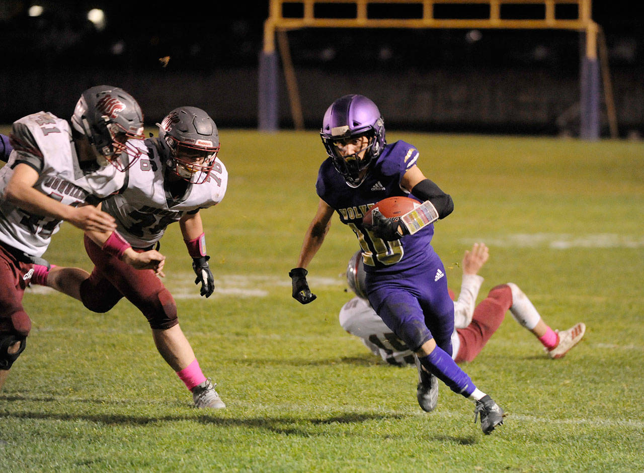Sequim’s Garrett Hoesel, right, looks for running room in the Wolves’ 14-12 non-league win over Hoquiam on Oct. 25. Sequim Gazette photos by Michael Dashiell