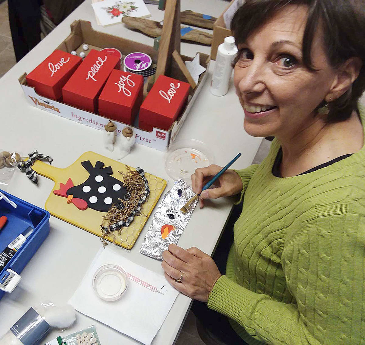 Former Sequim artist Karin Anderson, now a Santa Fe resident, helps contributors to the Dungeness Valley Luther Church Yuletide Bazaar at a recent “work session” to craft items for the annual event. Submitted photo
