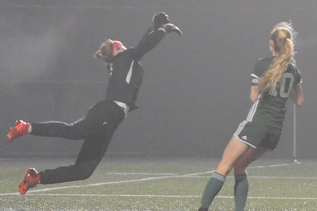Sequim Wolves goalkeeper Olivia Hale (left) parries a long shot away while Port Angeles Roughriders star Millie Long (right, 10) lurks near goal during their District 3 playoff tournament match at Peninsula College on Nov. 9. Port Angeles won 1-0 thanks to a goal from Long, but the Wolves had already qualified for the 2A state playoffs. Sequim Gazette photo by Conor Dowley