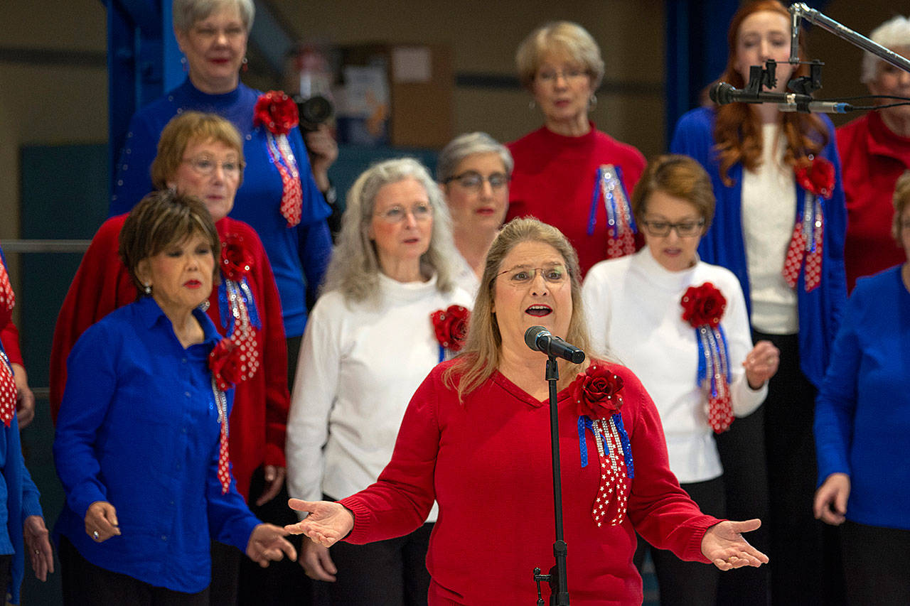 Grand Olympics Chorus Director Connie Alward performs a solo during the Veterans Day ceremony at U.S. Coast Guard Air Station/Sector Field Office Port Angeles on Monday. (Jesse Major/Peninsula Daily News)