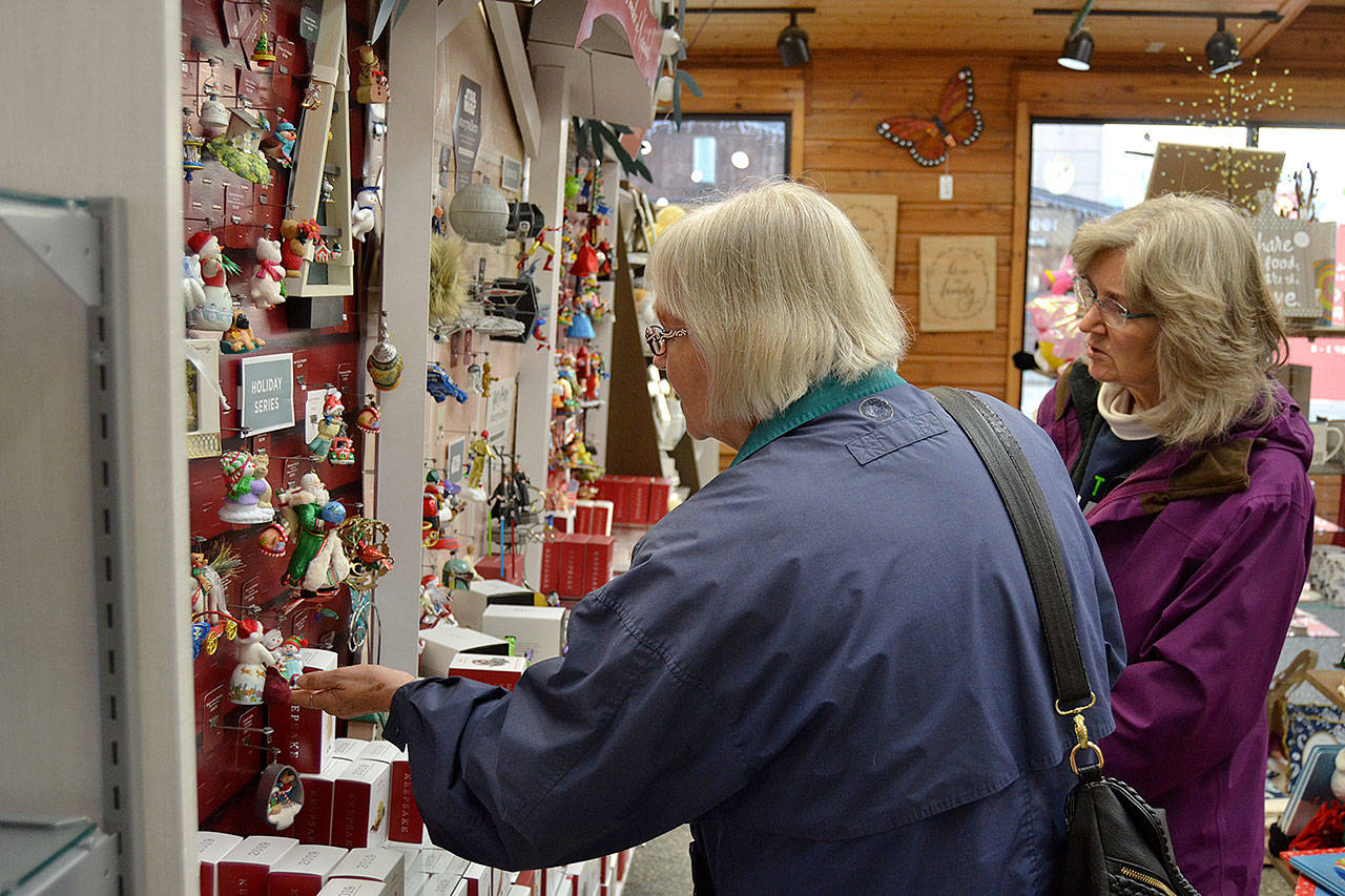 Sisters Cheryl Loucks and Charlene Davis both of Sequim look at Hallmark Keepsake ornaments inside the Co-Op Farm and Garden to add to their collection. The sisters said they’ve been collecting the ornaments for years with Charlene partial to series collections and Cheryl liking musical ones. Sequim Gazette photo by Matthew Nash