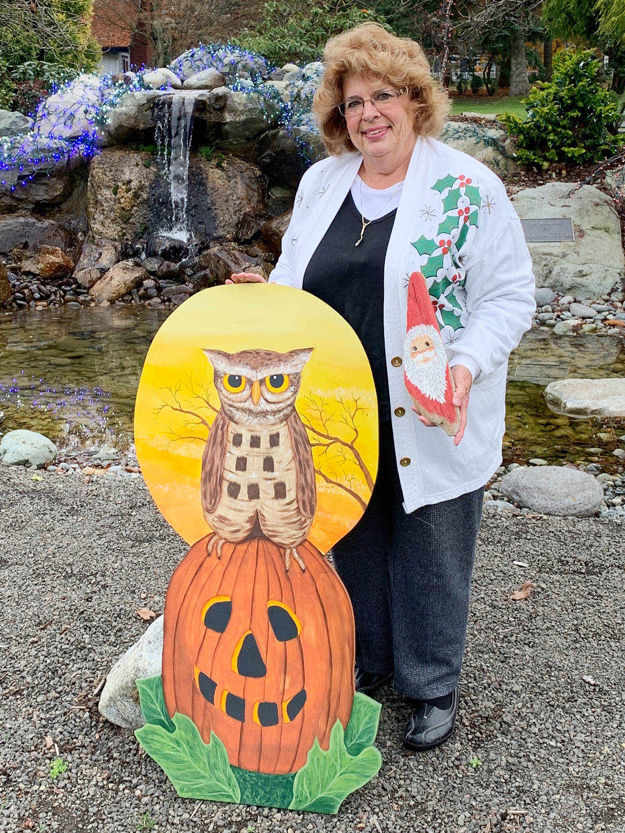 Marilynn Elliott displays whimsical Halloween and Christmas pieces she made from plywood and driftwood for her garden. Photo by Betty Harriman