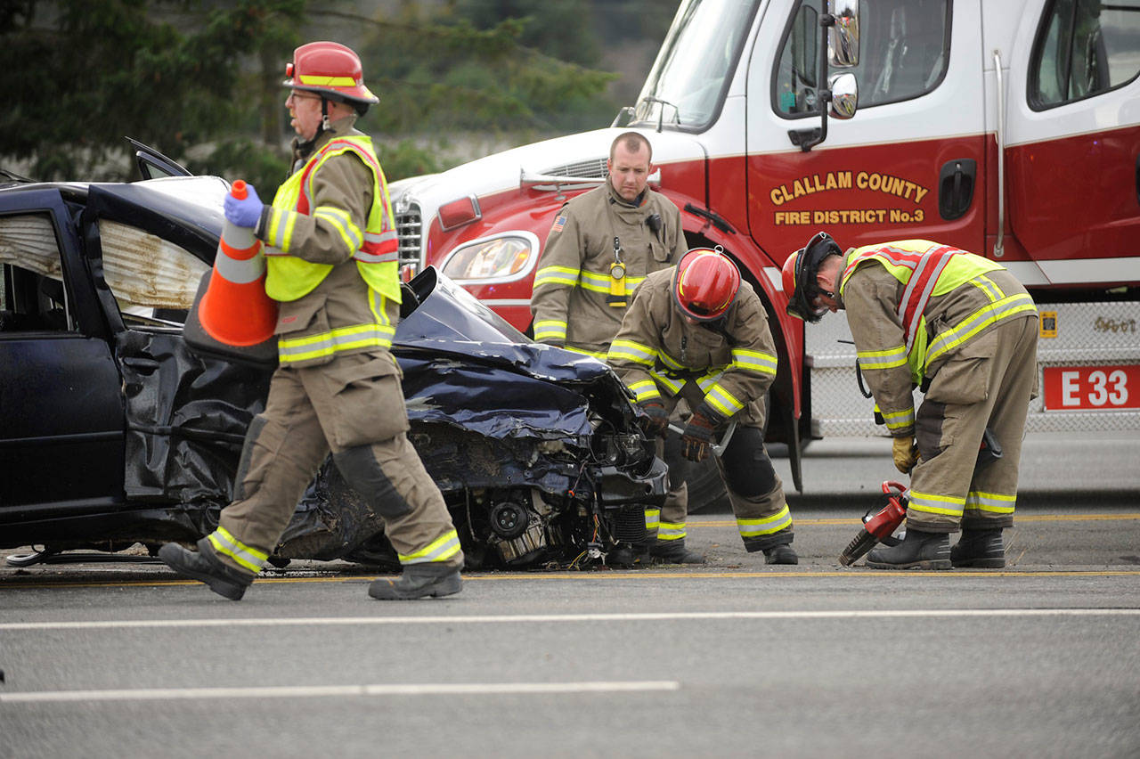 Firefighters with Clallam County Fire District 3 assess damages of a two vehicle collision on US Highway 101 near Gilbert Road on Dec. 3. Three people involved were sent to area hospitals. Sequim Gazette photo by Michael Dashiell