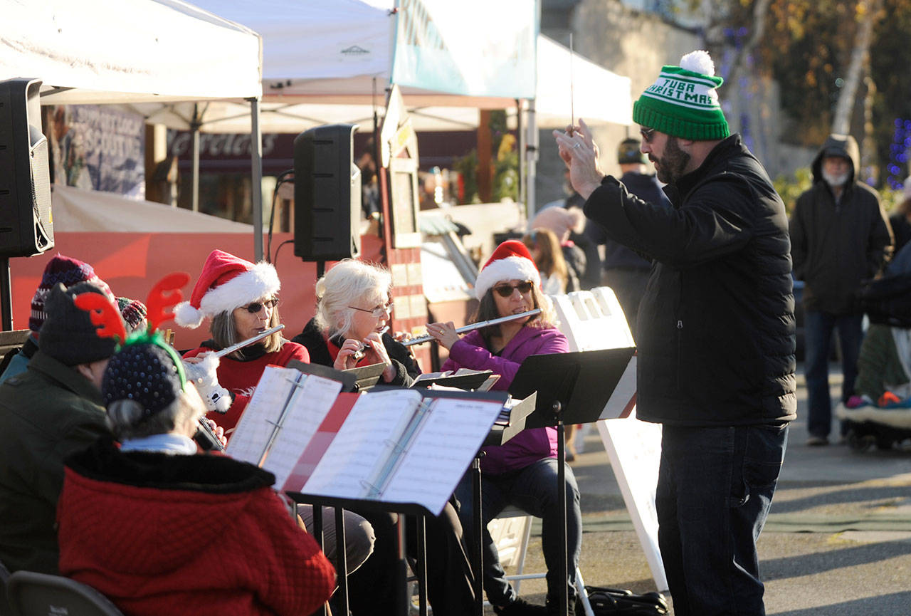 Director Tyler Benedict, right, pictured here leading the Sequim City Band in some festive holiday-themed tunes at the Home Town Holidays in downtown Sequim on Nov. 30, directs the band at the group’s annual “Joyous Sounds” holiday concert set for 3 p.m. Sunday Dec. 15, at the Sequim High School auditorium. Sequim Gazette photo by Michael Dashiell