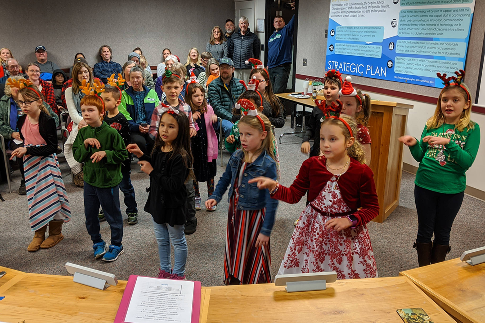 The Haller Elves sing and sign Christmas carols to the school board on Dec. 16. The second grade Elves included a deaf student, who performed alongside them. Sequim Gazette photo by Conor Dowley