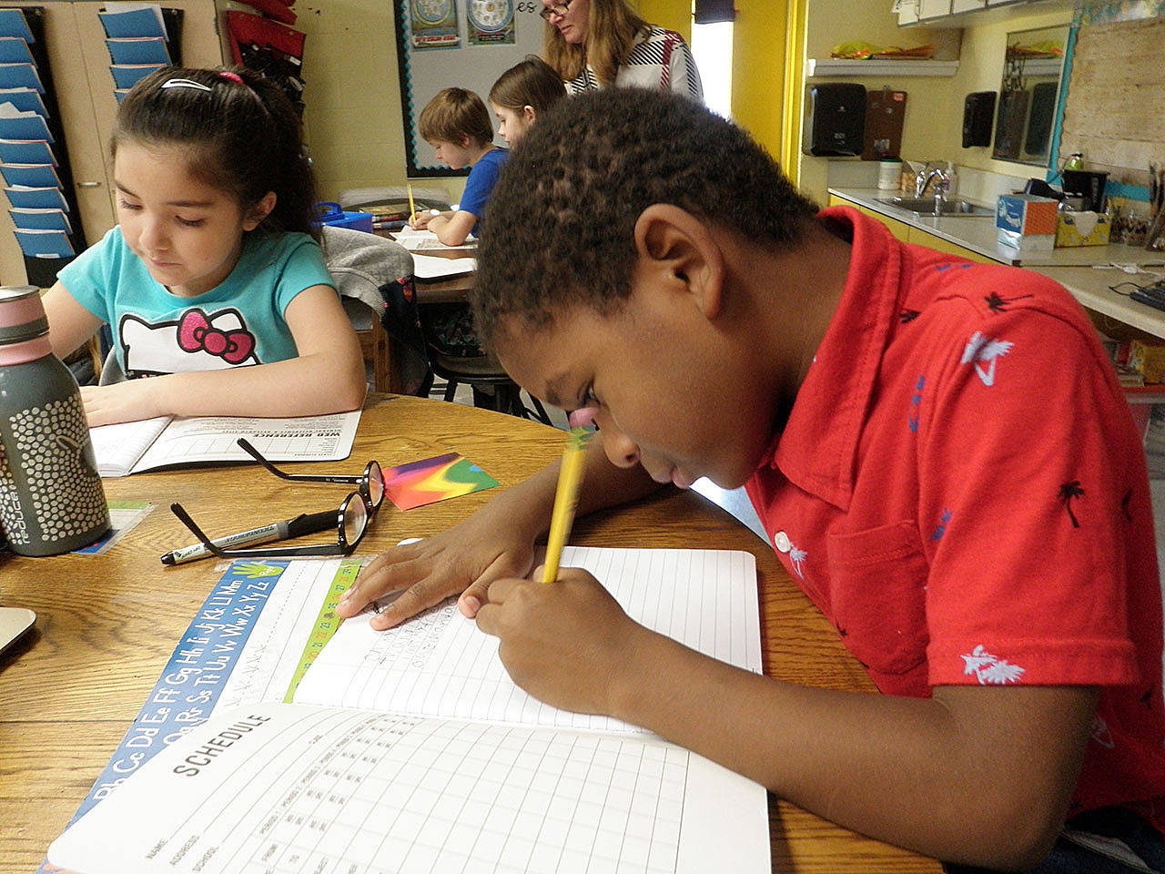 Second-graders Camren Williams, right, and Michelle Marquez get to work on their writing task.