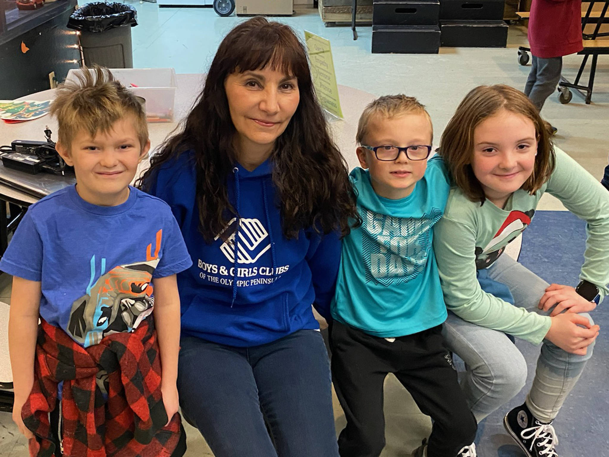 Mary Budke, second from left, sits with, from left, Scotty Janssen, Dalton Wilkinson and Seren McClurken in the games room of the Carroll C. Kendall Unit of the Boys & Girls Clubs of the Olympic Peninsula in Sequim. Submitted photo
