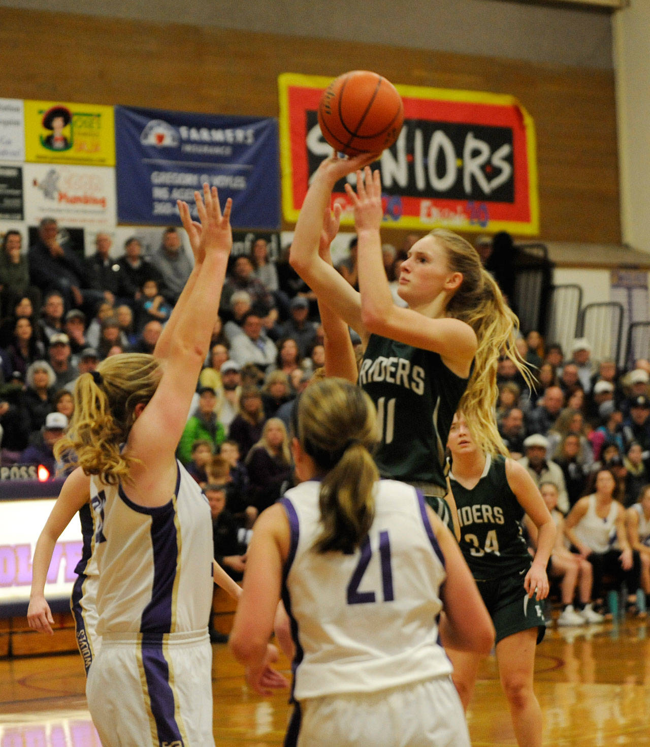 Port Angeles’ Millie Long, right, puts up a shot over the Sequim defense in the Roughriders’ 64-42 win at Sequim on Jan. 18. Long had 12 points. Sequim Gazette photo by Michael Dashiell