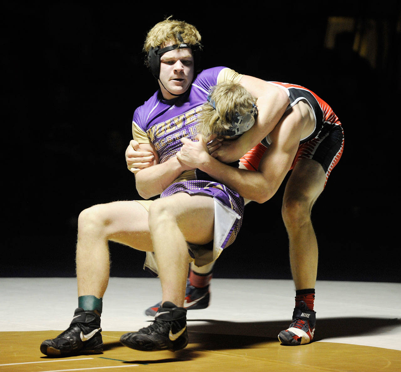 Left, Sequim junior Isaiah Cowan wrestles his way back from a 12-7 deficit in the third period to pin Port Townsend’s Wes Blue on Jan. 23. Right, Sequim’s Tevin Oakes, right, goes head to head with Port Townsend’s Ike Banks. Oakes won with a first period pin.