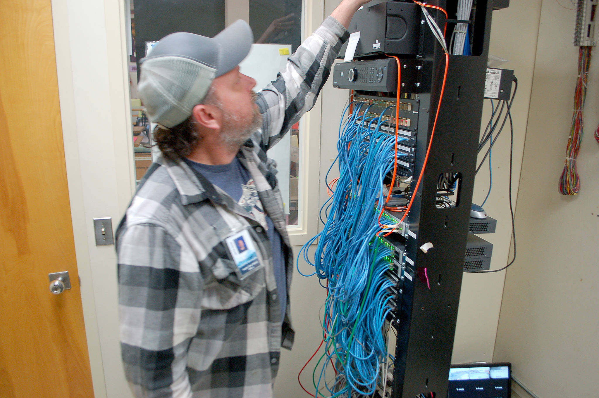 Sequim School District network technician Scott Harmsen checks on a network distribution point in the Sequim High School library. Sequim Gazette photo by Conor Dowley