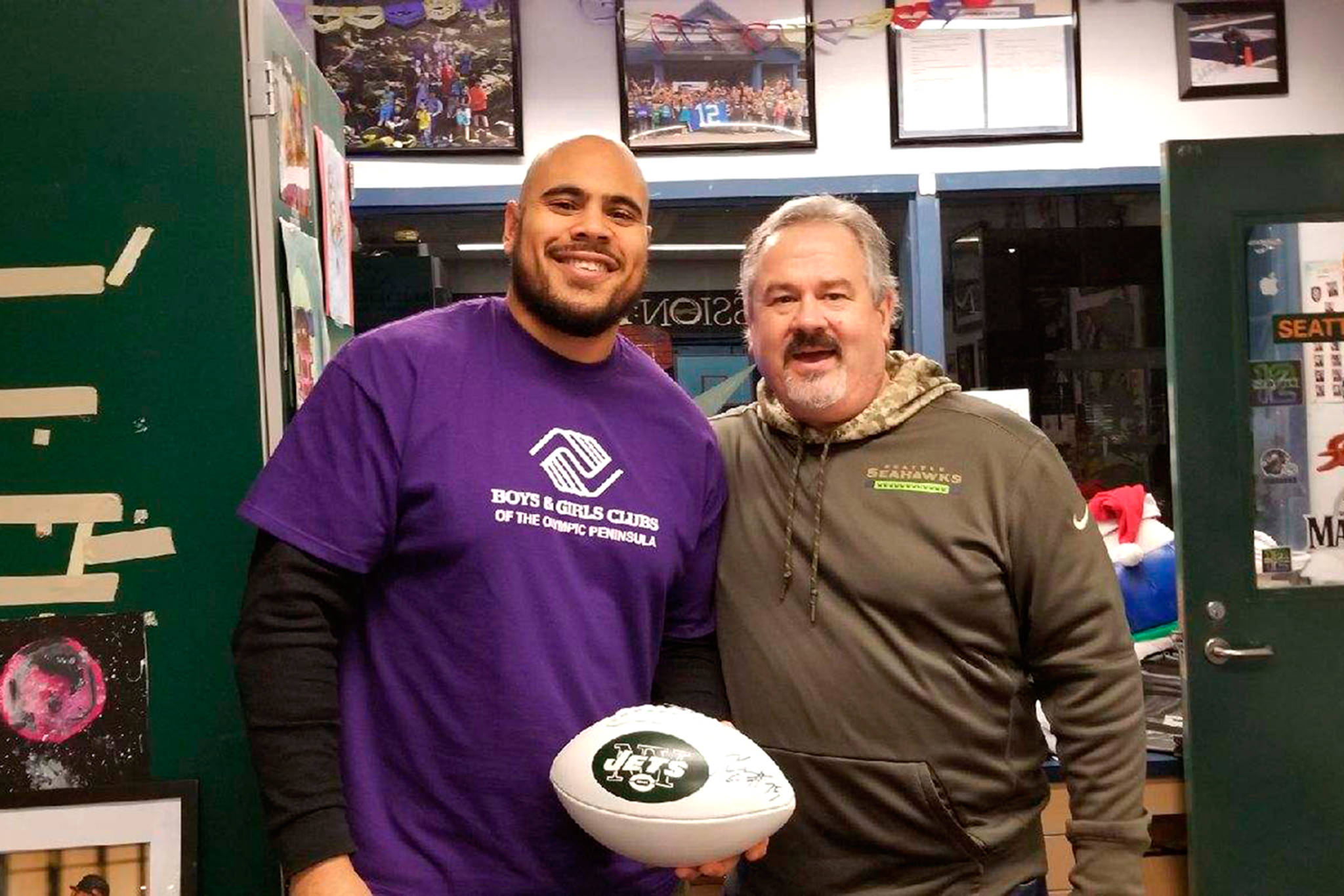 Dave Miller, Sequim Boys & Girls Club unit director (at right), stands with New York Jets’ defensive end Xavier Cooper during Cooper’s visit with club members in 2018. Miller resigned from his unit director position at the Carrol C. Kendall Unit in late January. Photo courtesy of the Boys & Girls Club of the Olympic Peninsula