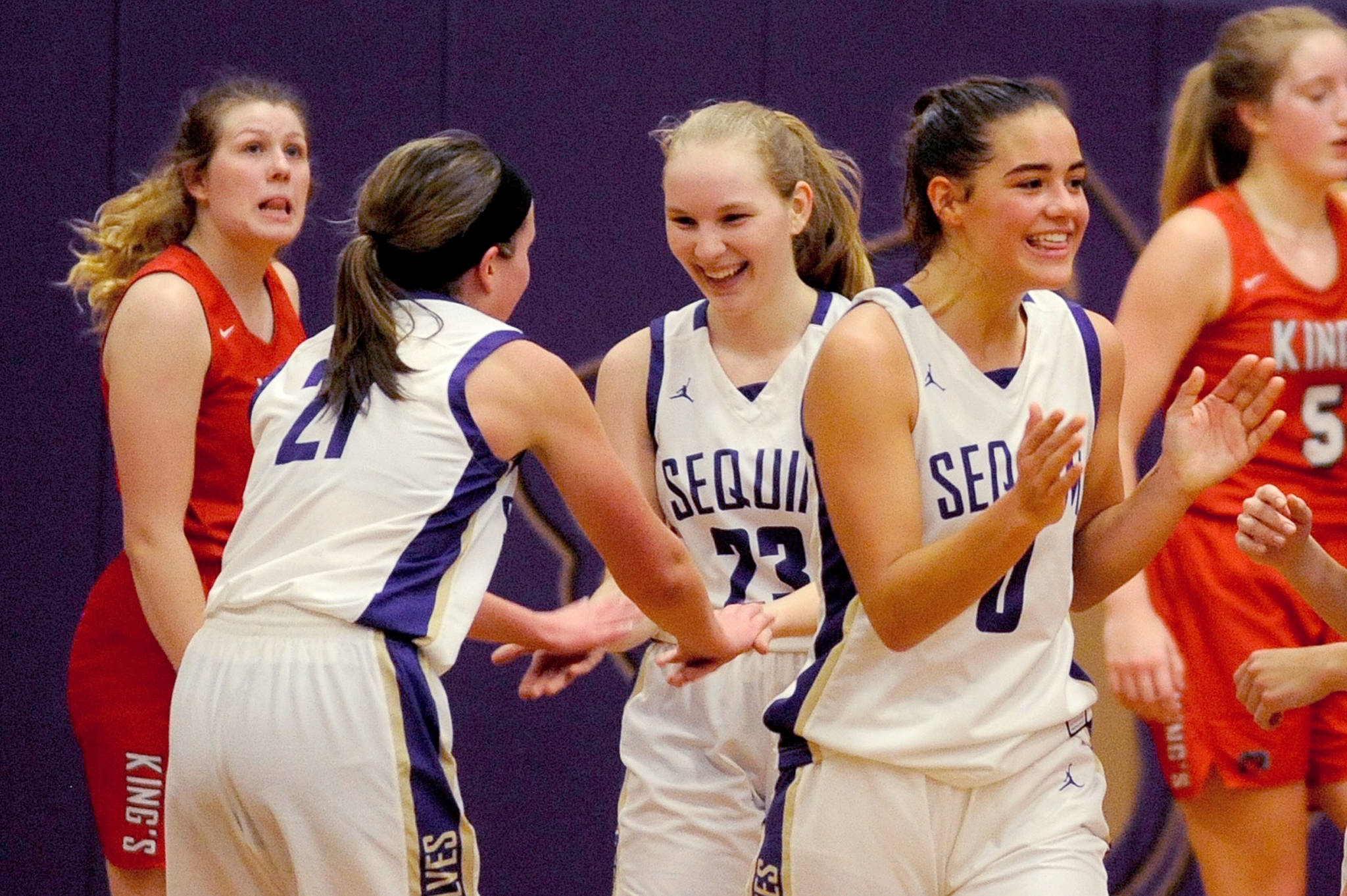 Kalli Wiker, Melissa Porter, and Hope Glasser (left to right) celebrate after the final buzzer of the Sequim Wolves’ 60-52 win over the Kings Knights on Jan. 29.