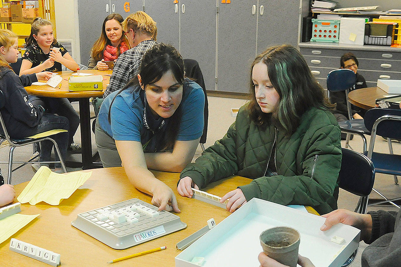 First-grade teacher Melissa Withrow, center, helps students and parents play a game of Upwords during Family Reading Night on Jan. 29. Sequim Gazette photos by Michael Dashiell