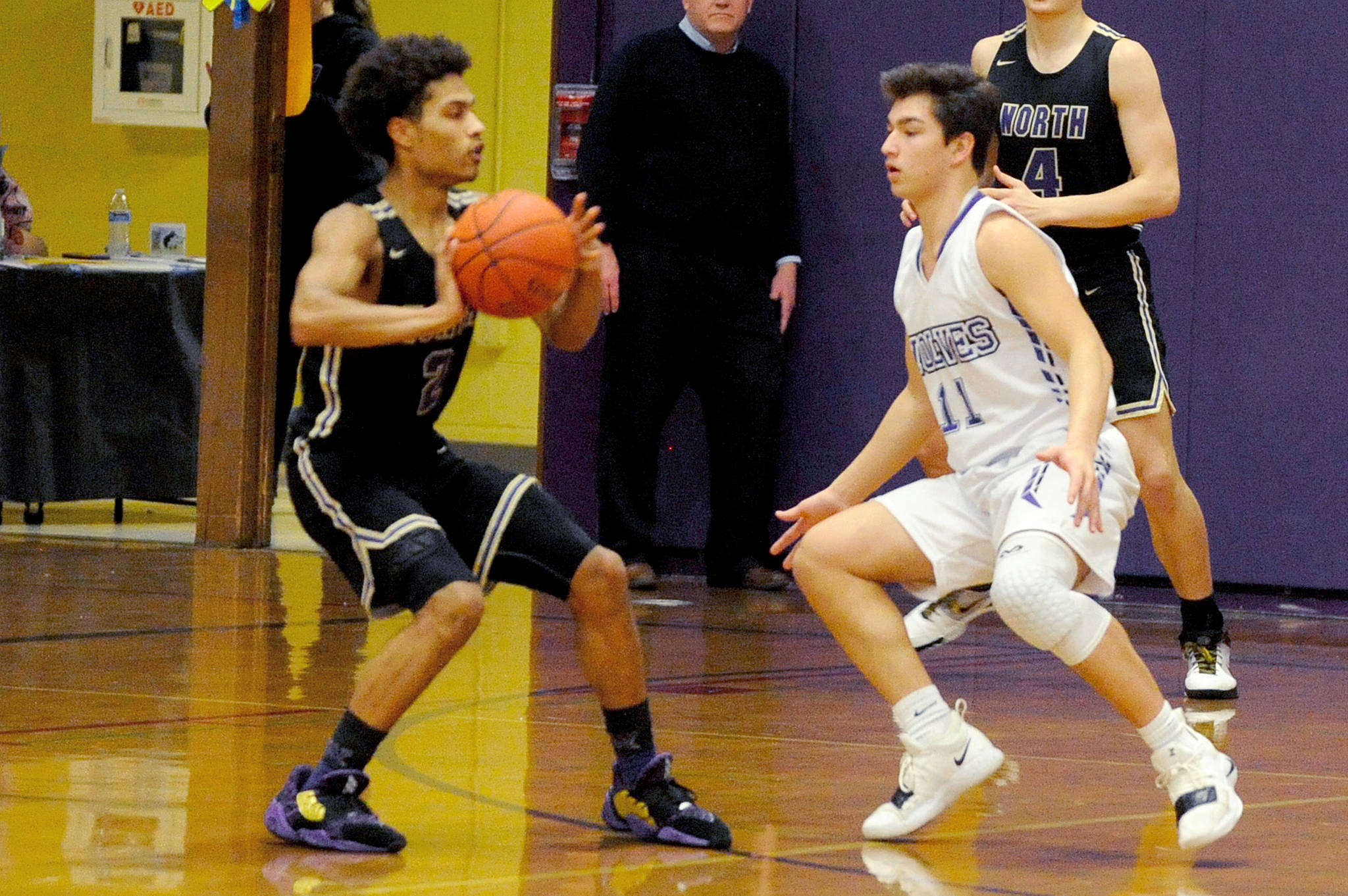Sequim Wolves guard Micheal Young (11) guards North Kitsap Vikings guard Kobe McMillian (left) during the first quarter of the Vikings’ 83-42 win over the Wolves on Jan. 31. Sequim Gazette photo by Conor Dowley