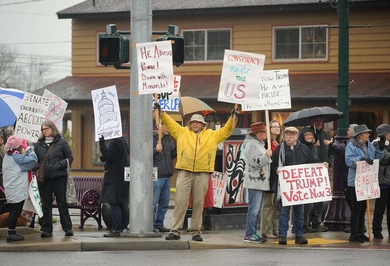 Leroy Martin, and executive board member with the Clallam County Democrats, joins a crowd at the corner of Sequim Avenue and Washington Street on Feb. 5. About 70 protesters braved the wet, cold conditions to voice their displeasure following the impeachment acquittal of President Donald Trump earlier that day. The protest was organized by Indivisible Sequim, whose representatives said prior to the event that, “Republican Senators have refused to call witnesses for a fair trial — even though a large majority of Americans want to see witnesses testify.” Sequim Gazette photo by Michael Dashiell