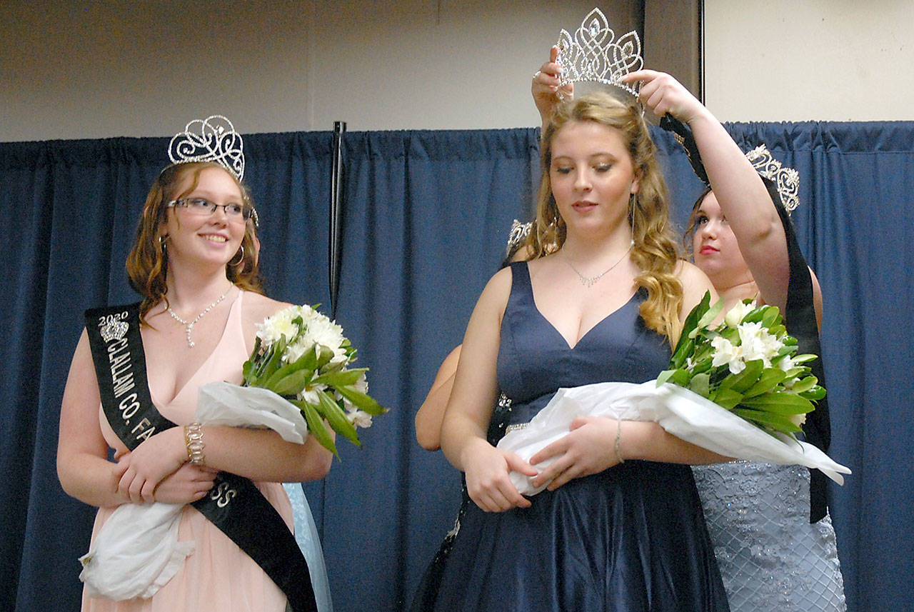 The 2020 Clallam County Fair Queen Anna Menkal receives her crown from 2019 Queen Saydee Peters as 2020 Princess Hannah McDaniel looks on, at left, during a coronation at the Clallam County Fairgrounds on Feb. 8 in Port Angeles. The girls, both from Port Angeles, will represent the fair at parades and festivals across Northwest Washington and preside over the county fair in August. Photo by Keith Thorpe, Olympic Peninsula News Group