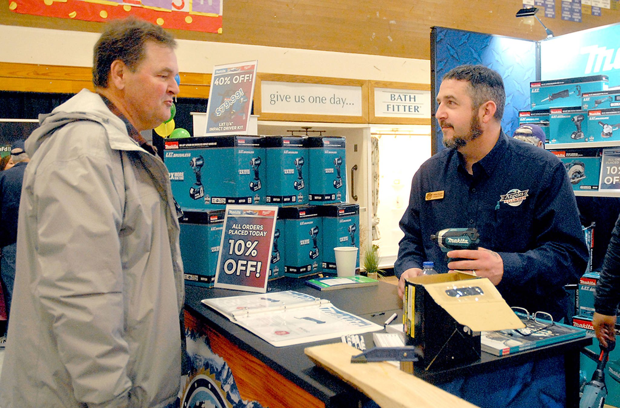 Robert Atkinson of Sequim, left, talks about power tools with Mike Deese, a contractor sales representative for Angeles Millwork at the company’s display booth at the 23rd annual Building, Remodeling and Energy Expo on Feb. 15 in the Sequim High School gym. The event, hosted by the North Peninsula Building Association, featured more than 50 vendors offering building products and services. Photo by Keith Thorpe/Olympic Peninsula News Group