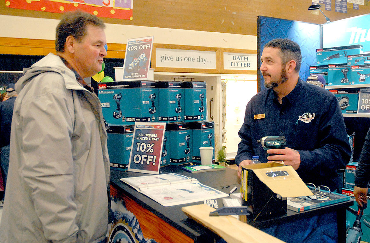 Robert Atkinson of Sequim, left, talks about power tools with Mike Deese, a contractor sales representative for Angeles Millwork at the company’s display booth at the 23rd annual Building, Remodeling and Energy Expo on Feb. 15 in the Sequim High School gym. The event, hosted by the North Peninsula Building Association, featured more than 50 vendors offering building products and services. Photo by Keith Thorpe/Olympic Peninsula News Group