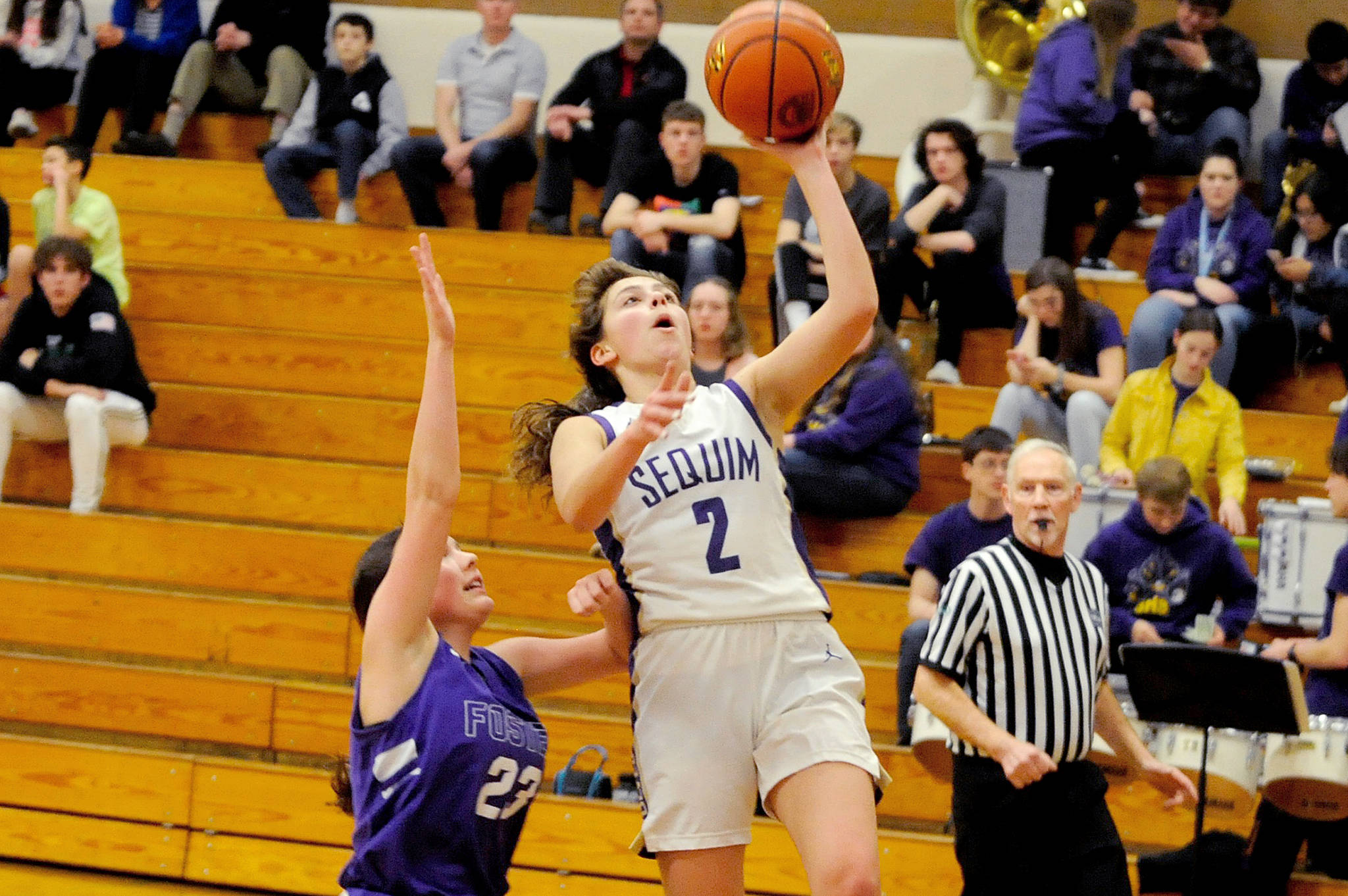 Sequim Wolves guard Jessica Dietzman goes up for a first-quarter layup while being defended by Foster Bulldogs guard Kelcie Newnom during the Wolves’ 92-22 district playoffs win over the Bulldogs on Feb. 12. Dietzman scored 18 points with five steals and four assists, and her defense helped spark numerous fast breaks throughout the game. Sequim Gazette photo by Conor Dowley