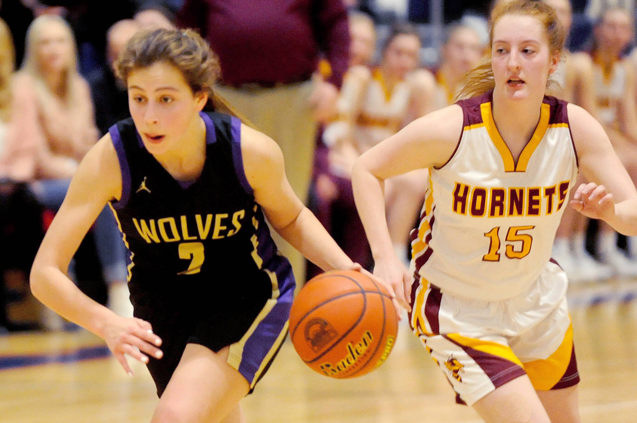 Sequim Wolves guard Jessica Dietzman (2) drives up the court with White River Hornets guard Kara Marecle (15) in close pursuit. Dietzman lead the Wolves in scoring with 14 points while Marecle had a game-high 22 as the Hornets beat the Wolves 57-53 in a district playoff loser-out game on Feb. 20 to qualify for the regional round of the 2A State Championships. Sequim Gazette photo by Conor Dowley