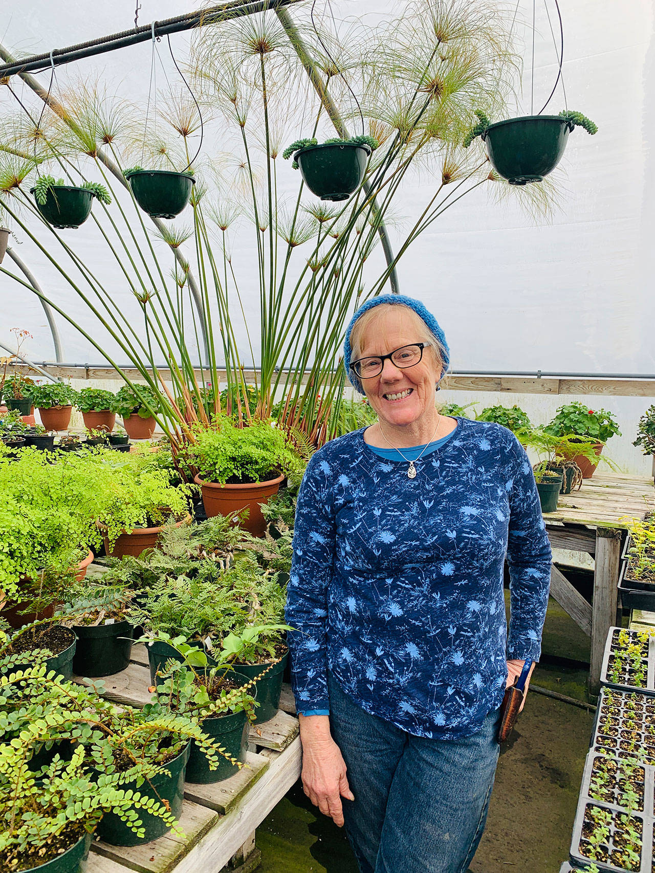 Leilani Wood shares a smile after nourishing the plants — and her soul — in one of many Sunny Farms’ greenhouses she co-manages. Photo by Betty Harriman