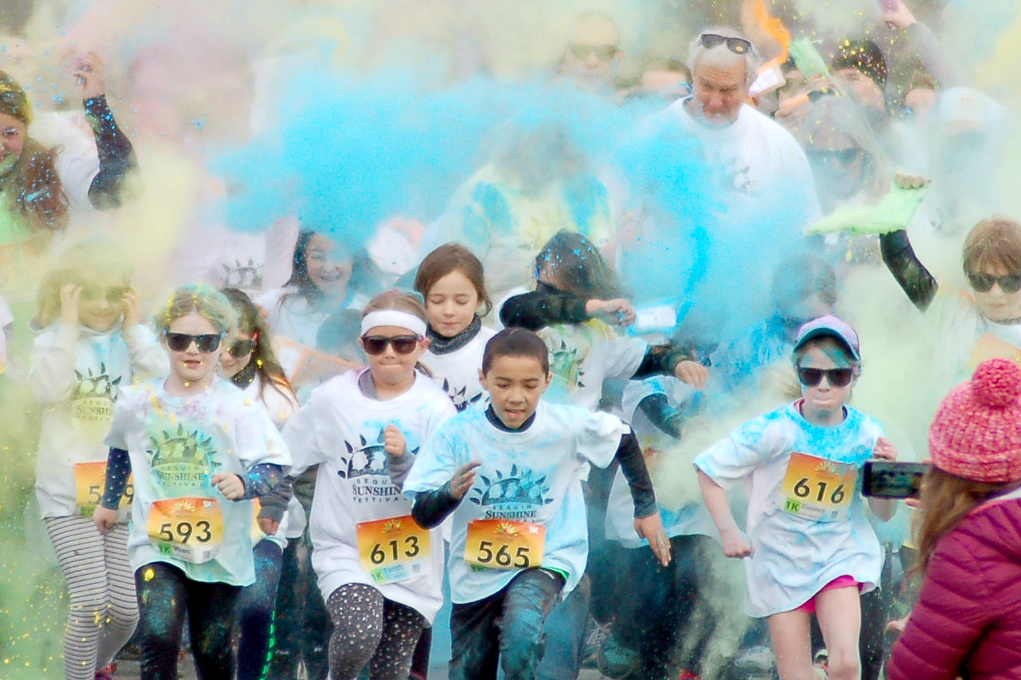 A group of children runs through the colored powder to start the Sequim Sunshine Festival Sun Fun Color Run 1K run at the Albert Haller Playfields on March 11. Sequim Gazette photo by Conor Dowley