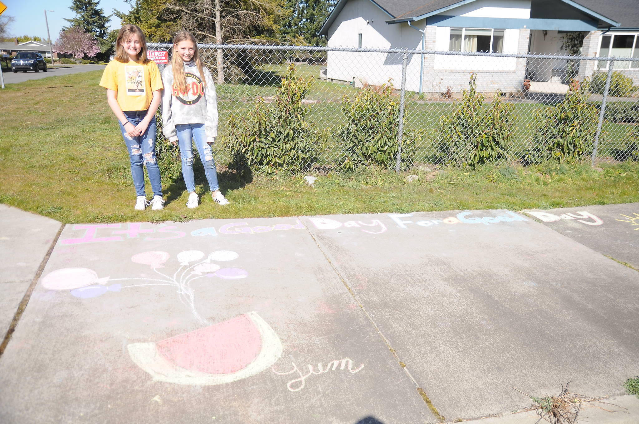 At left, Bailey Stein, 11, Brooklyn Fatherson, almost 11, provide some chalk-fueled cheer on East Fir Street on March 20. Sequim Gazette photo by Michael Dashiell