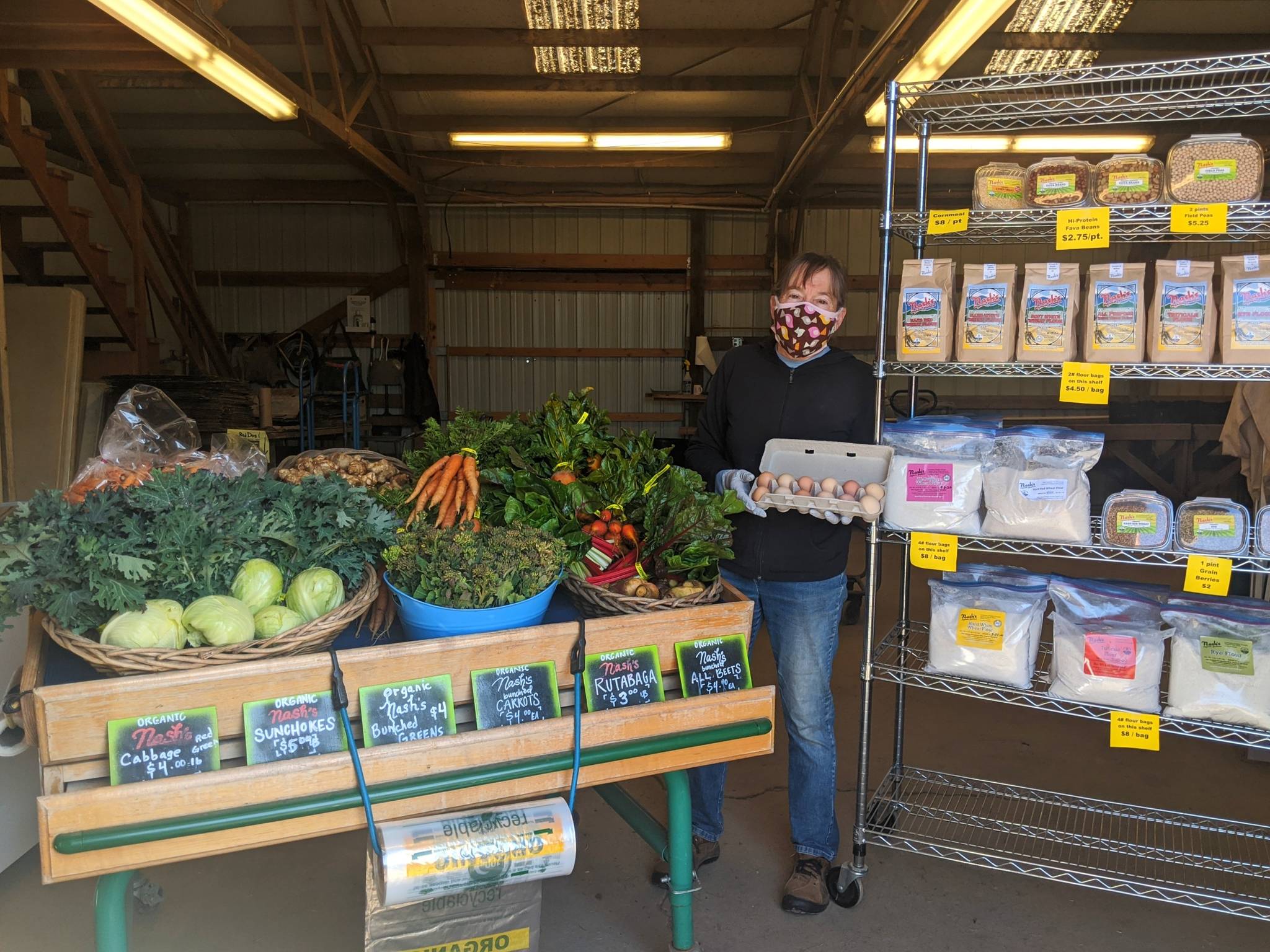 Nash’s Farm Stand owner Patty McManus shows a low-contact way to buy local vegetables, camelina oil, flour, grain and eggs. Photo by Emma Jane Garcia